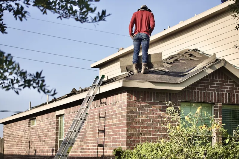 Professional roofer working on a residential roof in Brass Castle